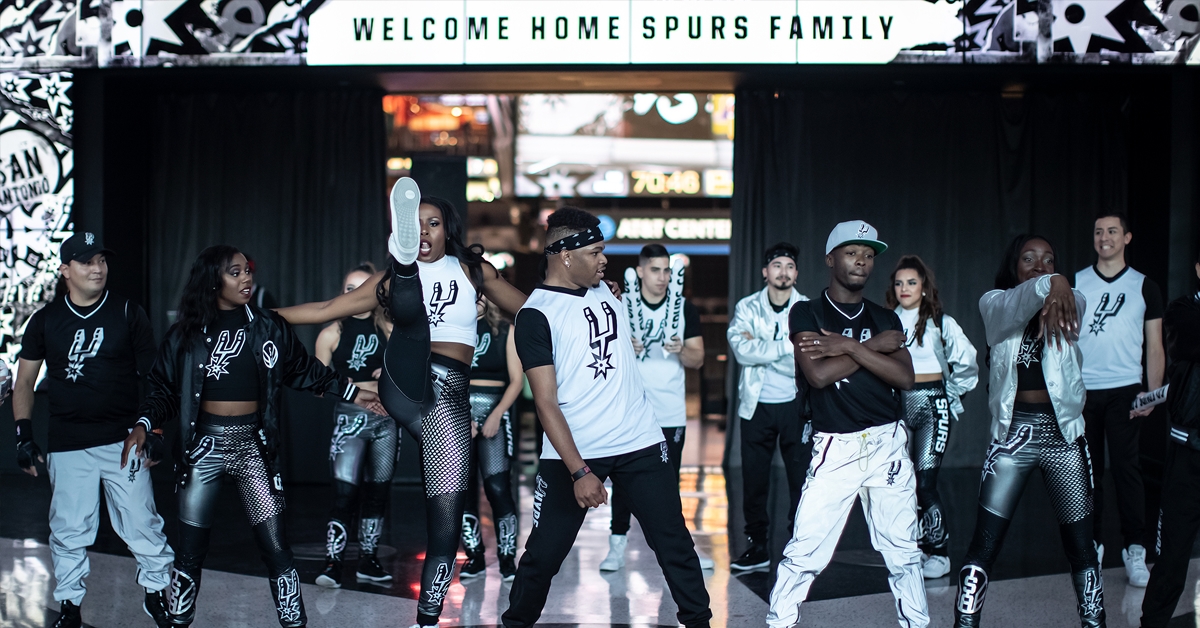 San Antonio Spurs Hype Squad members at the AT&T Center before a game during the 2019/2020 NBA season. Uniforms designed as part of SS&E Brand Engagement's creative campaign for the season, San Antonio Spurs 2019/20 creative, Brand Engagement, Spurs Sports and Entertainment, San Antonio Spurs, Spurs Creative Director, Pistons Creative Director, Justin Winget, Brandon Gayle, Becky Kimbro, R.C. Buford, Lori Warren, Innovation, Spurs, Design